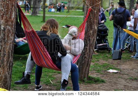 CLUJ-NAPOCA ROMANIA - APRIL 1 2016: Young people relaxing in hammocks in the Central park during the Big Hammock Day