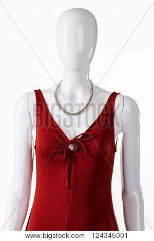 Red dress with silver nacklace. Female mannequin wearing silver accessory. Lady's stretch clothing and necklace. Evening garment for modern women.