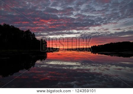 Sunrise reflected in the water of a bay along Maine's coast
