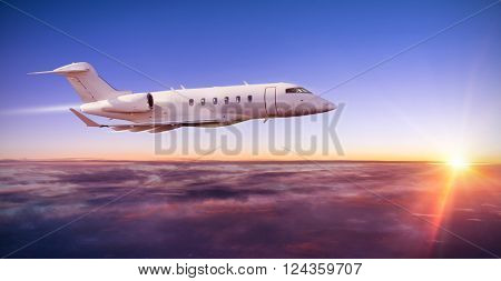 Private jet plane flying above clouds in dramatic sunset light
