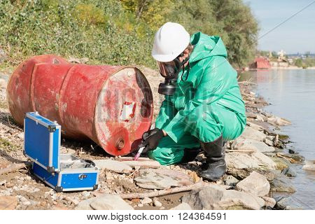 Environmentalist taking sample at pollution site outdoors