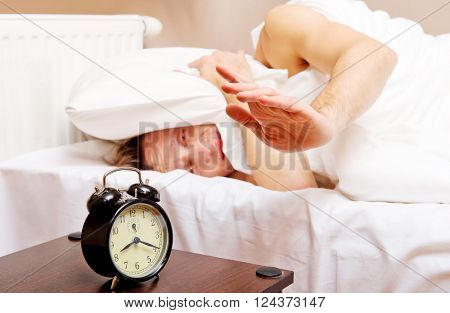 Man trying to sleep, when alarm clock ringing