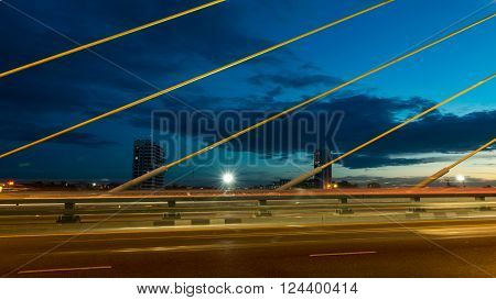 The bridge construction on twilight and river reflection at night Rama 8 Bridge in Bangkok Thailand