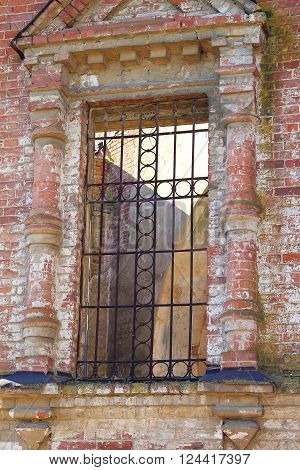 Old window with rusty bars in summer