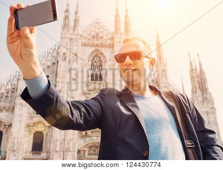 Man take a selfie photo on Duomo di Milano background