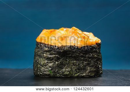 Japan gunkanmaki sushi baked with cheese on blue background copyspace