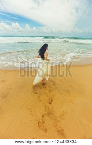 Happy girl walking along the coast of the beautiful island
