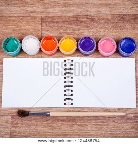 Paints, brushes, colored pencils and album - drawing tools on a desk