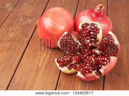 Pomegranate Punica granatum fruit composition placed over the wooden boards surface