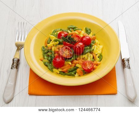a delicious colored spatzle on yellow dish