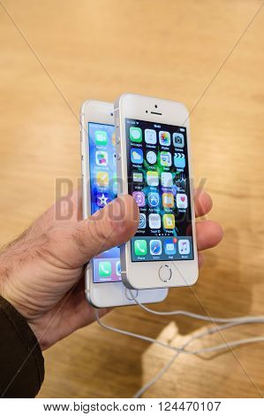 PARIS FRANCE - APR 4 2016: Man comparing iPhone 6s and the new Apple iPhone SE during the sales launch of the latest Apple Inc. smartphone and iPad Pro at the Apple store in Paris France