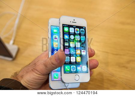 PARIS FRANCE - APR 4 2016: Man comparing iPhone 6s and the new Apple iPhone SE during the sales launch of the latest Apple Inc. smartphone and iPad Pro at the Apple store in Paris France