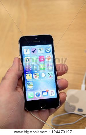 PARIS FRANCE - APR 4 2016: Man holding black version of the latest Apple iPhone SE during the sales launch of the latest Apple Inc. smartphone and iPad Pro at the Apple store in Paris France
