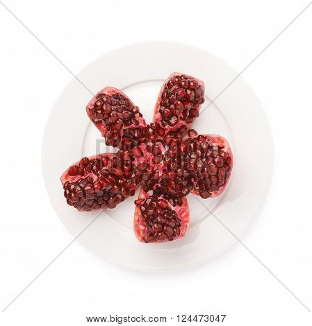 Split open flower served on the white ceramic plate pomegranate Punica granatum fruit isolated over the white background