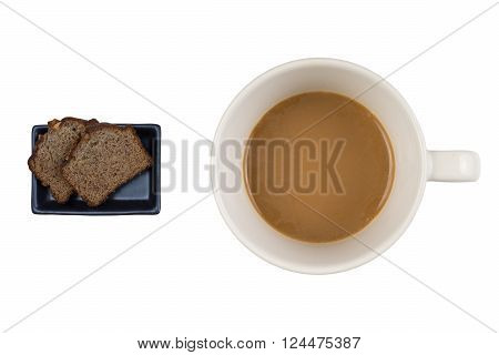 A hot dup of coffee and cake on a white background