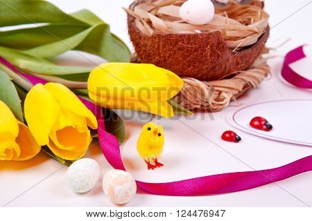 Easter eggs and yellow tulips on a white background. Celebration. Spring. Easter.