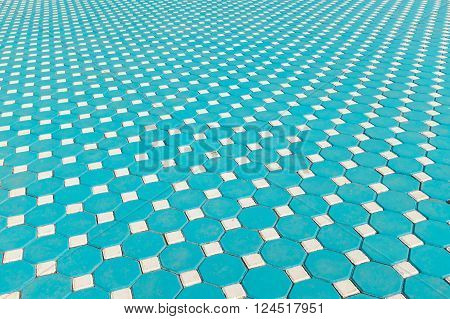 Footpath made by square blue tiles with illusional perspective