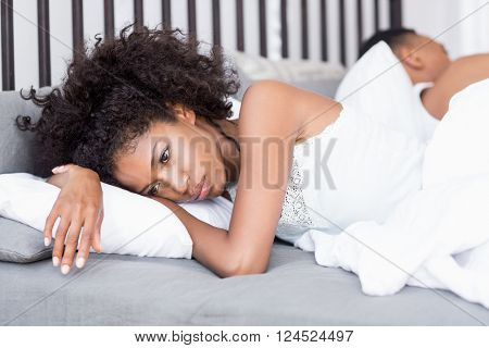 Young couple back to back ignoring each other in the bedroom