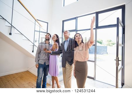 Real estate showing a house project on a digital tablet to young couple in their new home
