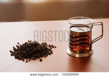 glass mug and poured tea on wooden table