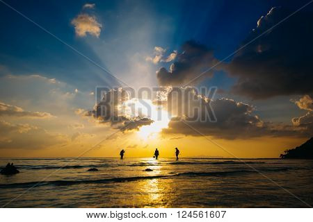 silhouette fishermens at sunset catch sea crabs