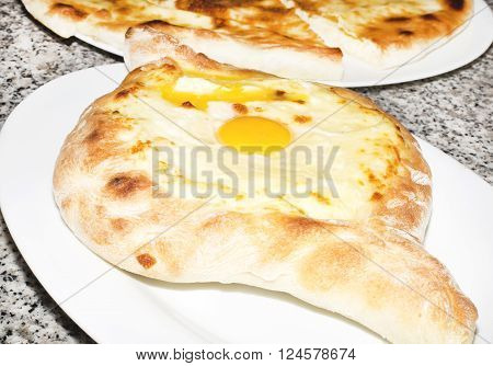 Traditional Dish Of Georgian Cuisine Filled With Cheese And Topped With A Raw Egg And Butter (ajaria