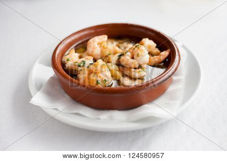 Fresh fried spanish garlic shrimp served in clay pot in local restaurant in Taganana on tropical island Tenerife Canary in Spain. Spanish food specialities.