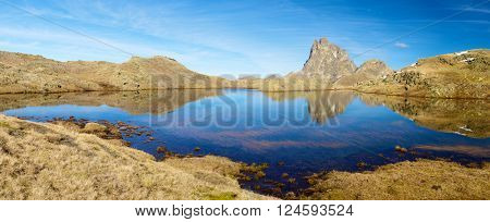 Midi Dossau Peak reflected in a lake. Ossau Valley, Pyrenees National Park, Pyrenees, France.