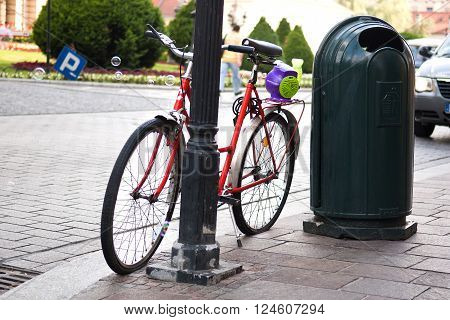 Bicycle standing on a sidewalk in European city with bubble generator blowing soap bubbles on it