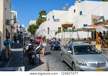 THIRA, SANTORINI, GREECE  - AUGUST 25, 2015: Street of Thira with many tourists and transport at Santorini island.