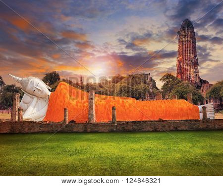 sleeping buddha statue and ancient brick pagoda against beautiful sun set sky with copy space use for beautiful asia scenic and religious background