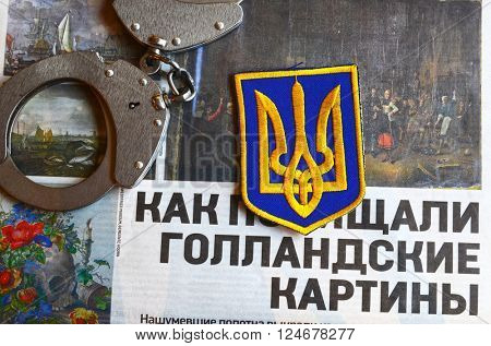 Kiev,Ukraine.FEB 20.ILLUSTRATIVE EDITORIAL.Chevron Ukrainian nazionalist battalion.Background - newspaper about West Frisian Museum stolen art . February 20,2016 in Kiev, Ukraine