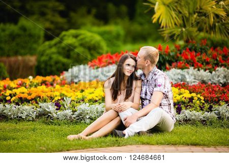 Cute teen couple lovely hugging in the garden flowers.