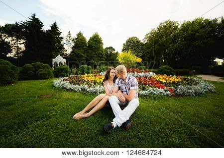 Cute teen couple lovely hugging in the garden flowers.