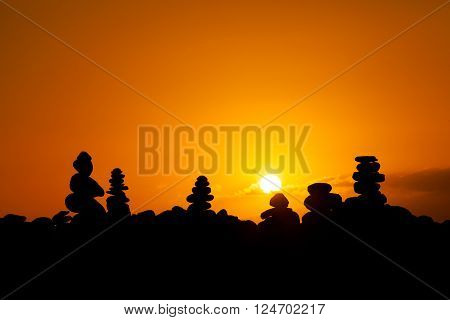 Summer sunset seascape with stone pile stacks silhouettes on tropical island Tenerife, Canary in Spain. Tranquil scene on Playa del Duque.