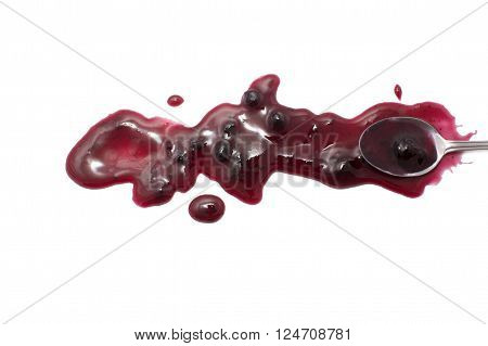 splashes, droplets and spilled blueberry jam with a spoon. Blot the huckleberry jam teaspoon and dipped in a sweet sauce. isolated on white background. flat lay, top view