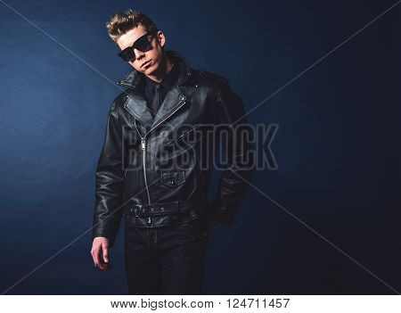 Macho retro 50s fashion man wearing shades and leather jacket.