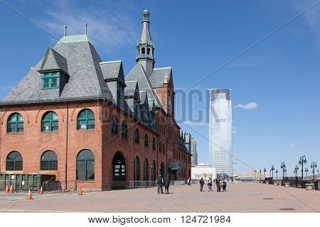 JERSEY CITY NEW JERSEY - MARCH 6: People enjoy the day at Liberty State Park on March 6 2016. The old CNJRR building and Goldman Sachs tower are seen.