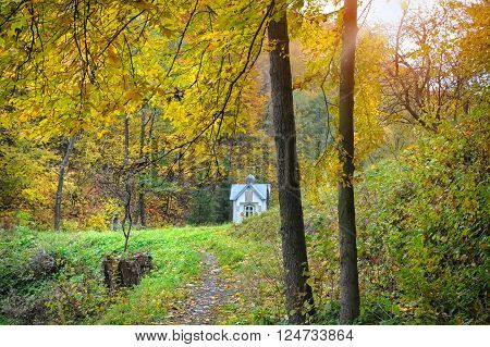 Autumn landscape with chapel and colorful trees