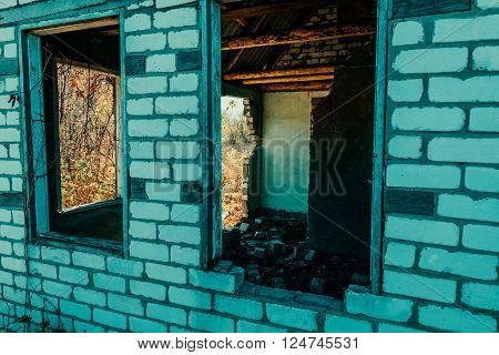 An old abandoned brick house with a broken window, closeup. As background for design of crisis.