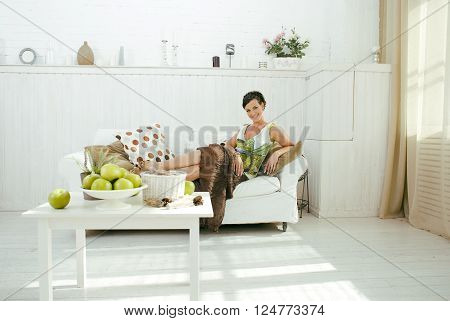young pretty real brunette woman at home laying on sofa, lifesyle people concept, bright white interior