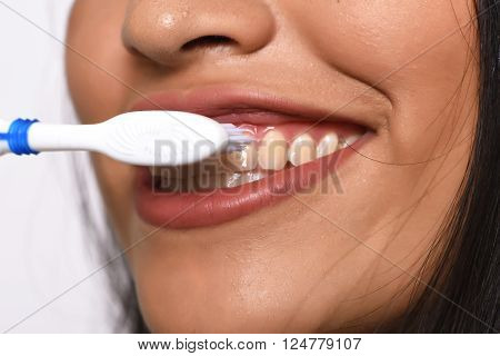 Close-up woman brushing her teeth. Isolated white background.
** Note: Shallow depth of field