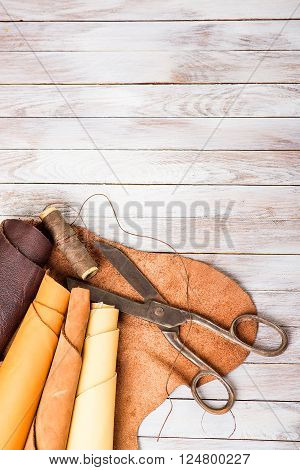 skin rolls with scissors and thread on a wooden background