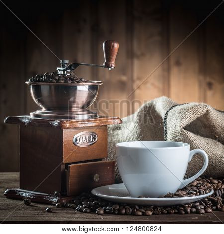 still life with coffee beans and old coffee mill on the wooden background 