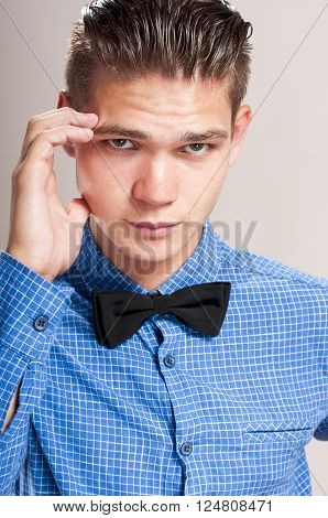 Refined man in a blue shirt with black bow tie