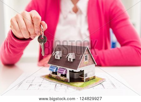 Female house agent holding keyring of rented house.