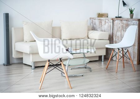 Smart space. View of white furniture specious room with chairs and sofa