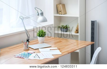 My workplace. View of the table standing in the corner near the shelf under the window