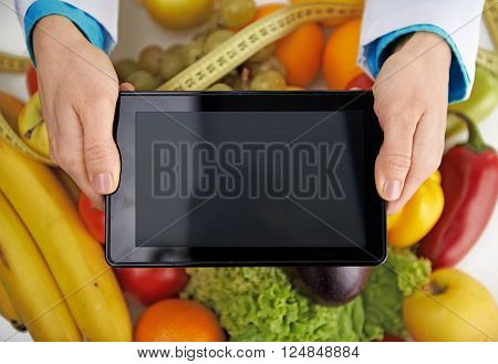 Close-up of doctor's hands holding tablet pc over fresh colorful fruits background. Medicine and technology.
** Note: Soft Focus at 100%, best at smaller sizes