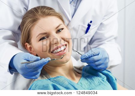 Close-up portrait of happy smiling dental care woman taking oral treatment in dentist office. Infected gum or tooth cure.